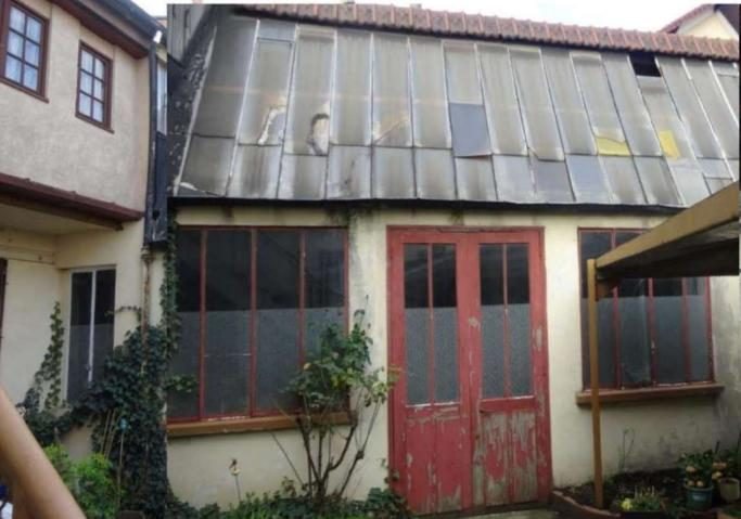 Ancien atelier sur cour avec verrière et menuiseries rouges avant travaux