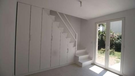 Pièce de l’extension avec escalier vers les combles et placards intégrés