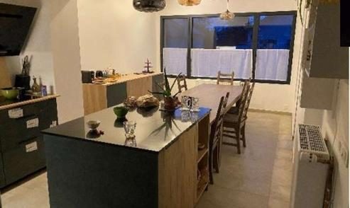 Espace repas éclairé par de grandes fenêtres