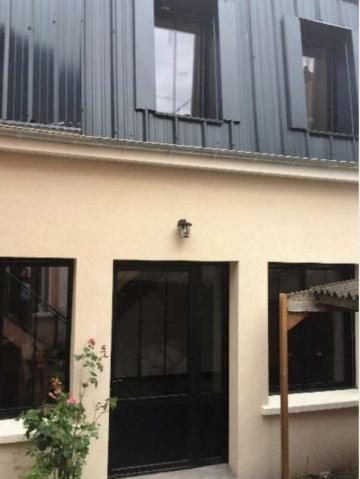 Façade enduite et menuiseries noires de style atelier sur cour