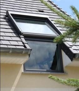 Fenêtre de toit intégrée à la toiture en tuiles anthracite
