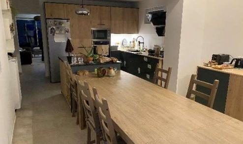 Îlot de cuisine noir et table à manger dans l’extension