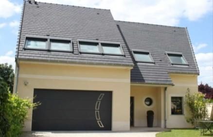 Façade sur rue avec garage intégré et lucarnes